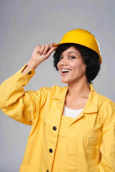 Счастливая улыбающаяся женщина-строитель в желтом защитном шлеме — стоковое фото
