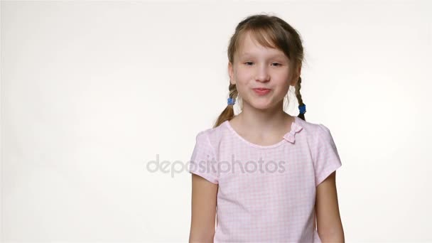 Niña con dos trenzas mirando a la cámara sonriendo — Vídeo de stock