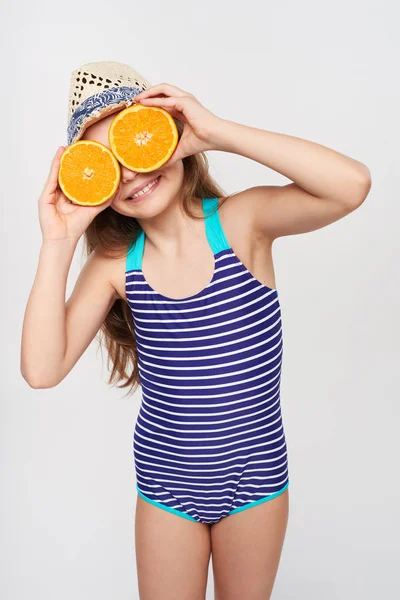 Girl in swimsuit making fake eyeglasses with oranges — Stock Photo, Image