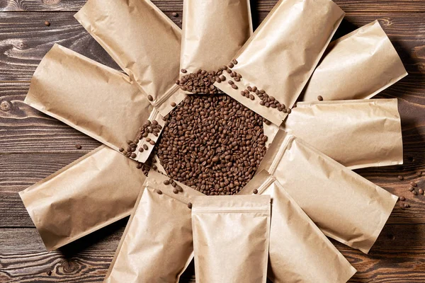 Many mock-up craft paper pouch bags with coffee beans in the center — Stock Photo, Image