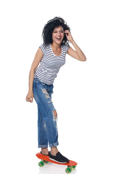 Szczęśliwa Kobieta w trudnej sytuacji dżinsy z deskorolka — Zdjęcie stockowe