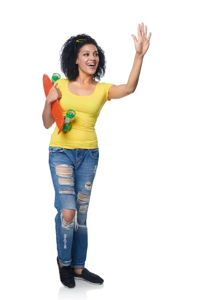 Mulher feliz em jeans angustiados com skate — Fotografia de Stock
