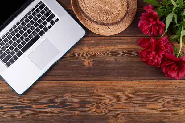 Vår sommar set med laptop, halm fedora hatt och röda blommor — Stockfoto