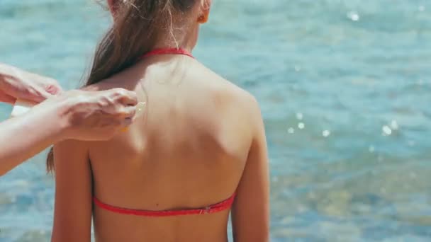 Mujer aplicando crema de protección solar en el hombro de sus hijas — Vídeos de Stock