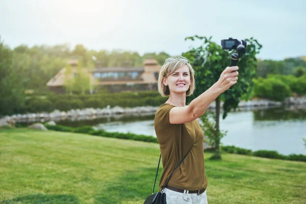 Mujer capturándose a sí misma con cámara personal — Foto de Stock