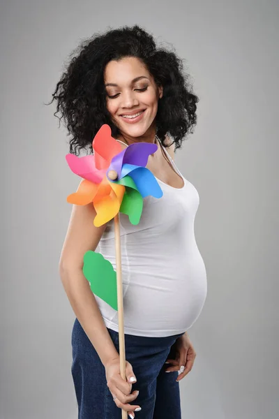 Mulher grávida com moinho de vento pinwheel multicolorido — Fotografia de Stock