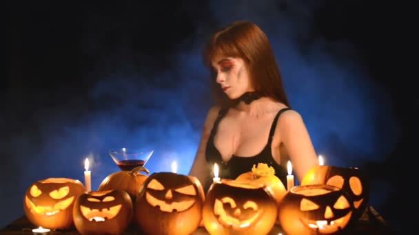 Woman with Halloween pumpkins holding cocktail glass — Stock Video