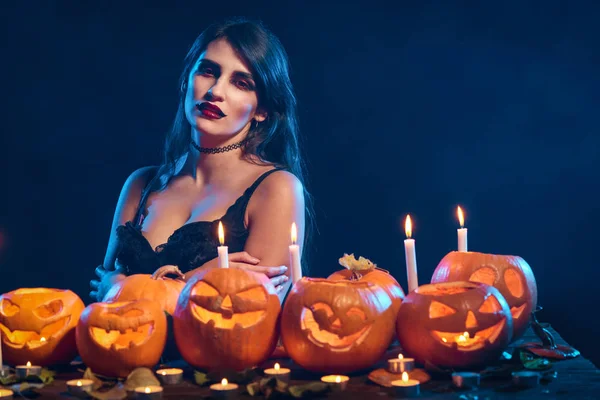 Beautiful witch with Halloween pumpkins — Stock Photo, Image