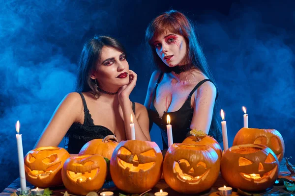 Due belle streghe sexy con zucche di Halloween — Foto Stock