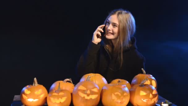 Ragazza in cappotto nero e cappuccio che esce dal fumo blu — Video Stock