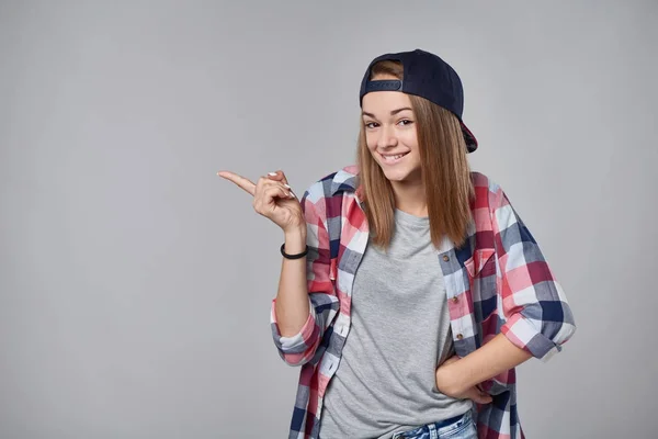 Adolescente menina apontando para o espaço vazio cópia — Fotografia de Stock