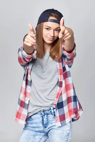 Дівчина-підліток вказує на камеру обома руками — стокове фото