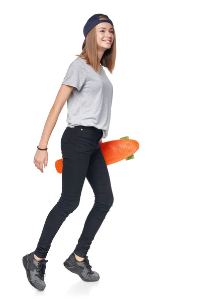 Teen ragazza in piena lunghezza a piedi con skate board — Foto Stock
