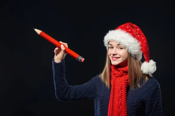 Girl in Santa hat writing on copy space — Stock Photo, Image