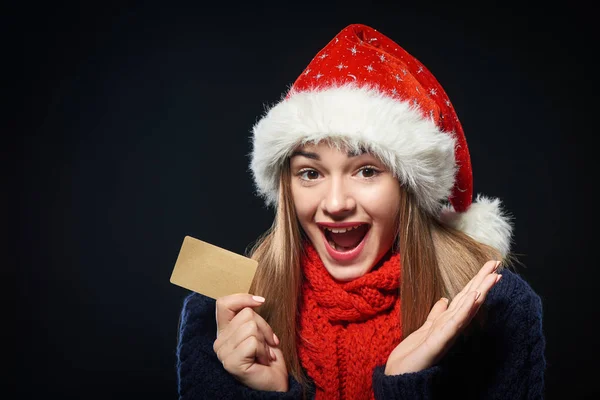 Surprised girl in Santa hat with blank credit card — Stock Photo, Image