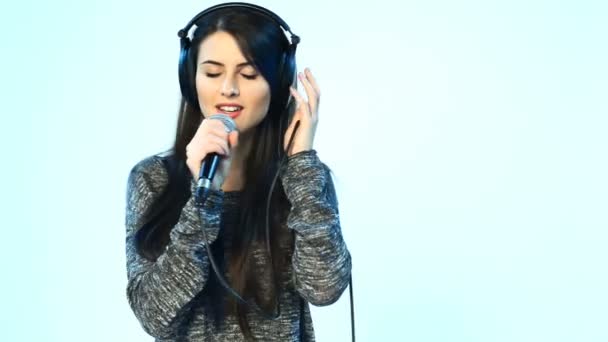 Жінка в навушниках з мікрофоном співає — стокове відео