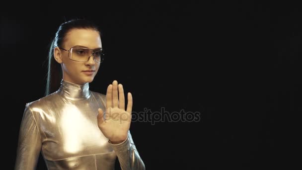 Futuristisk kvinna i silverkostym och glasögon tittar åt sidan — Stockvideo