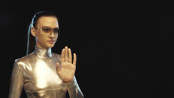 Mujer futurista en traje de plata y gafas mirando a un lado — Vídeos de Stock