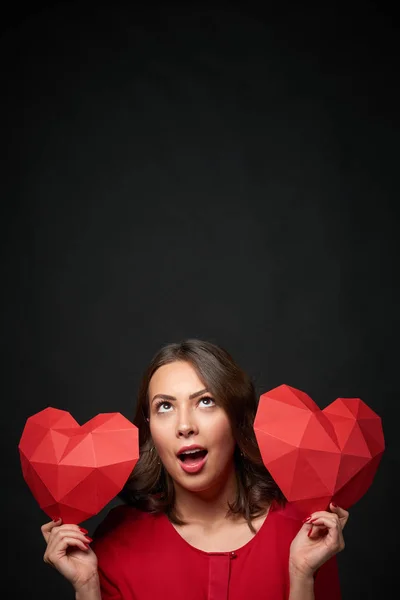 Mujer sonriente sosteniendo dos forma de corazón poligonal — Foto de Stock