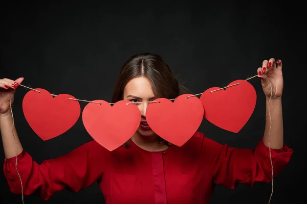 Woman holding thread with four heart shapes — Stock Photo, Image