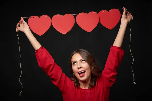 Woman holding thread with four heart shapes — Stock Photo, Image