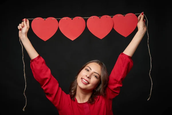 Woman holding thread with four heart shapes — Stock Photo, Image