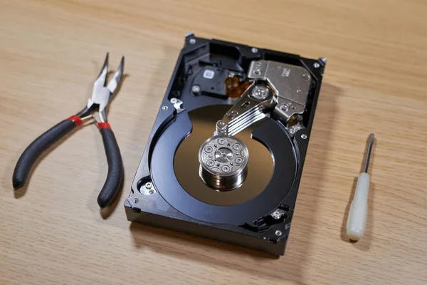 Disassembled hard disk drive with repair tools — Stock Photo, Image