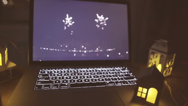 Открытый ноутбук с мигающими свечами на столе — стоковое видео