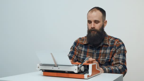 Hipster hombre escribiendo con una máquina de escribir vintage rojo — Vídeos de Stock