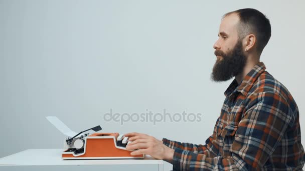 Hipster mannen att skriva med en röd vintage skrivmaskin — Stockvideo