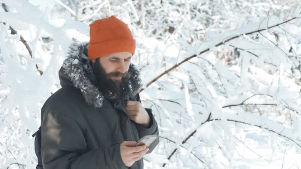 Uomo in una giornata nevosa invernale a parlare sul cellulare — Video Stock