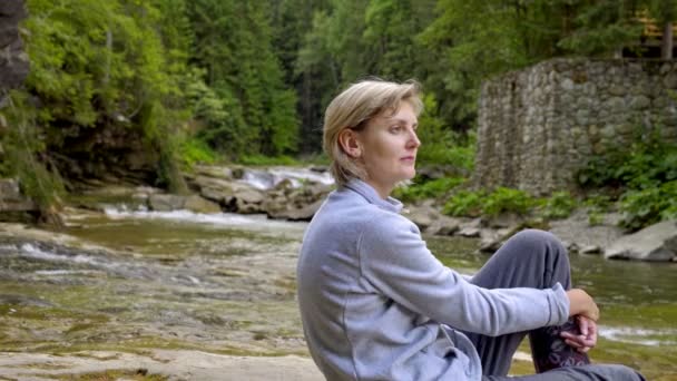 Žena a holčičky sedící na skále v horské řece — Stock video