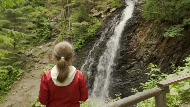 Flickan tittar på berget vattenfall — Stockvideo