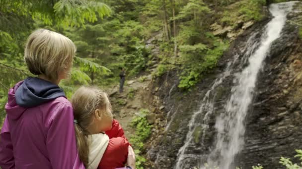 Familia viendo la cascada de montaña — Vídeos de Stock