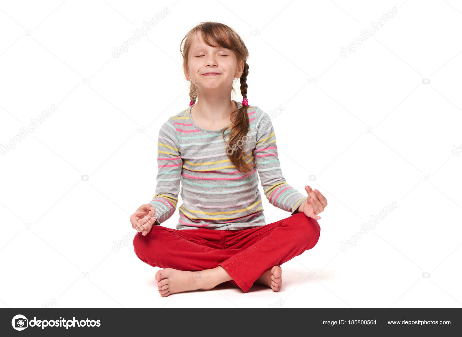 Маленькая девочка сидит в позе лотоса