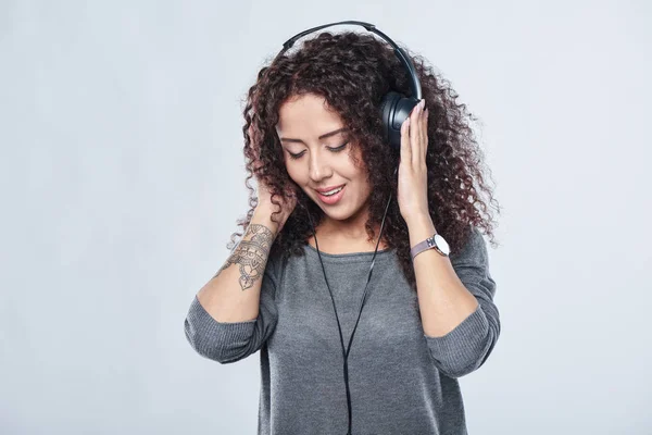 Vrouw luisterend naar muziek in hoofdtelefoon — Stockfoto