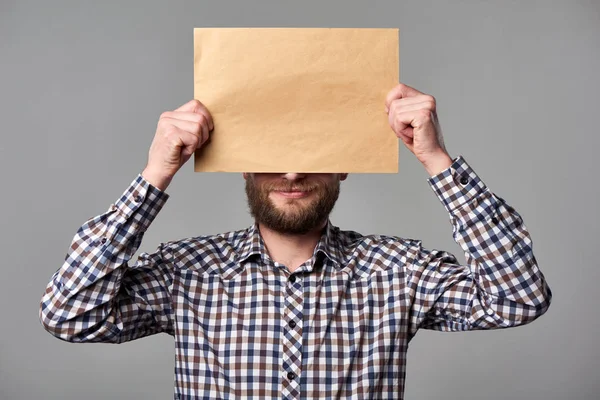 Homem barbudo segurando envelope marrom em branco — Fotografia de Stock