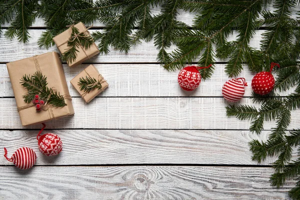 Kerst frame gemaakt van sparren takken met geschenkdoosjes op witte planken — Stockfoto