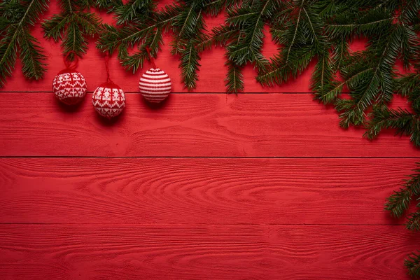 赤い板の上にボールとクリスマスツリーの枝 — ストック写真