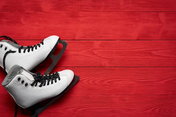 Paar weiße Schlittschuhe auf roten Holzplanken — Stockfoto