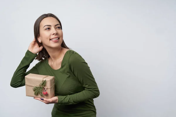 # Mutlu kız elinde bir hediye kutusu tutuyor # # Bir dal köknar ağacıyla el işi kağıdına sarılı # — Stok fotoğraf