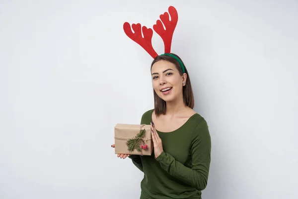 # Mutlu kız elinde bir hediye kutusu tutuyor # # Bir dal köknar ağacıyla el işi kağıdına sarılı # — Stok fotoğraf
