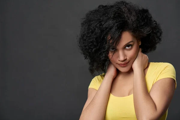 Discontent mixed race woman staring at camera touching her neck — Stock Photo, Image