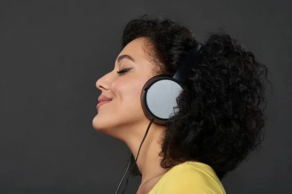 Vrouw luisteren muziek met gesloten ogen — Stockfoto