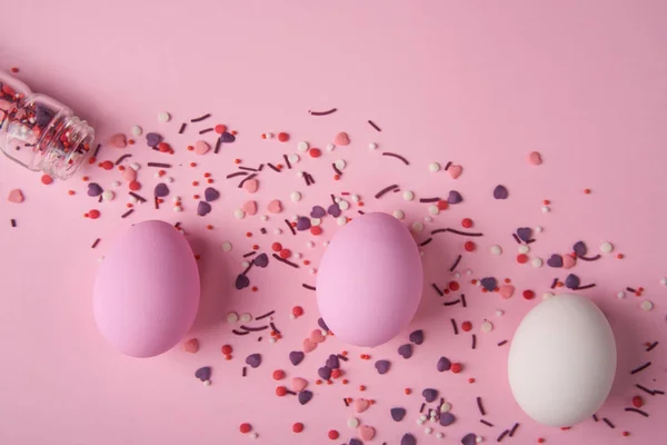 Easter eggs scattered on pink background with copy space above — Stock Photo, Image