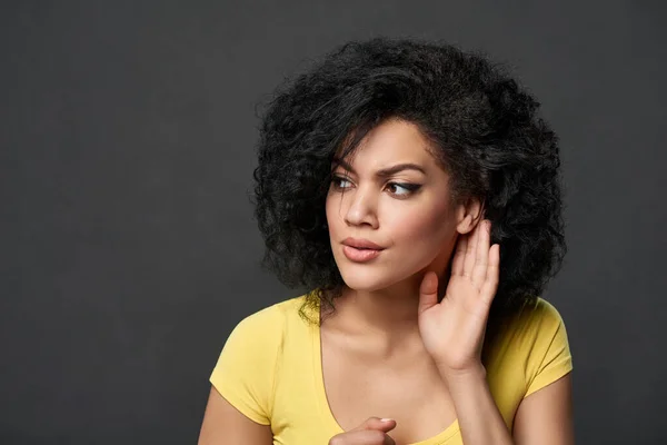 Wanita serius mendengar gosip dengan telinga yang melindungi telapak tangan — Stok Foto