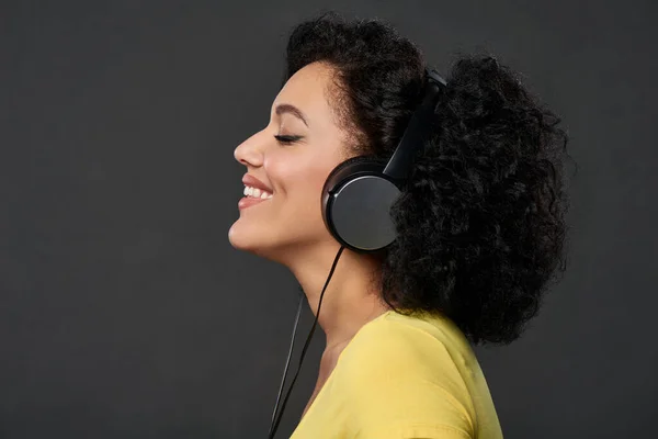 Perfil de uma mulher ouvindo música com olhos fechados — Fotografia de Stock