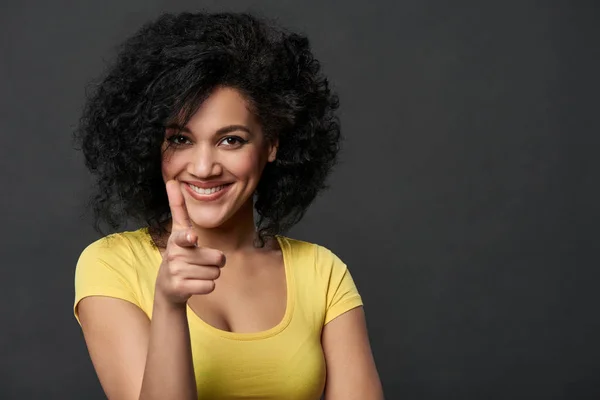 Sorrindo mulher apontando o dedo para a câmera — Fotografia de Stock