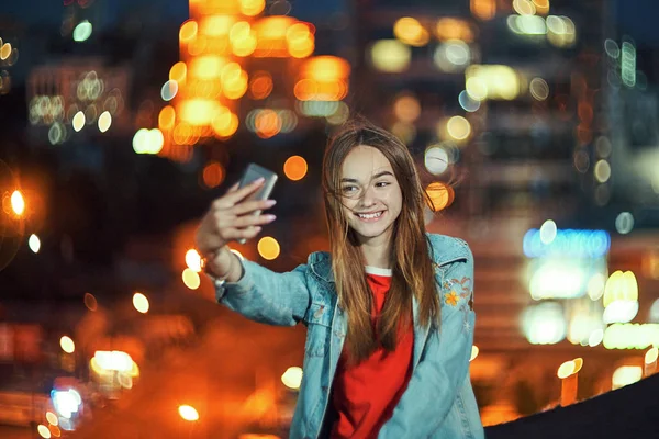 Chica adolescente en el fondo del paisaje urbano haciendo autorretrato con su teléfono inteligente — Foto de Stock