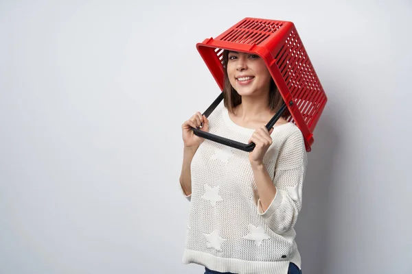 Сумасшедшая женщина кладет пустую корзину для покупок на голову — стоковое фото